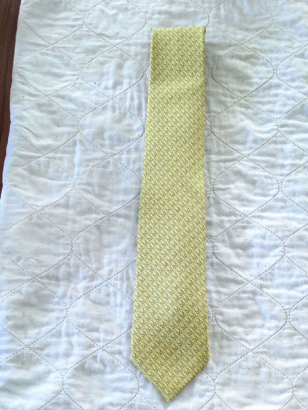 This is a Hermes yellow silk twill tie  with a grey pattern